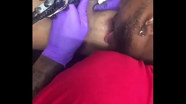 Gran Tatuadora cachonda multitarea chupando los pezones de un cliente tubo total